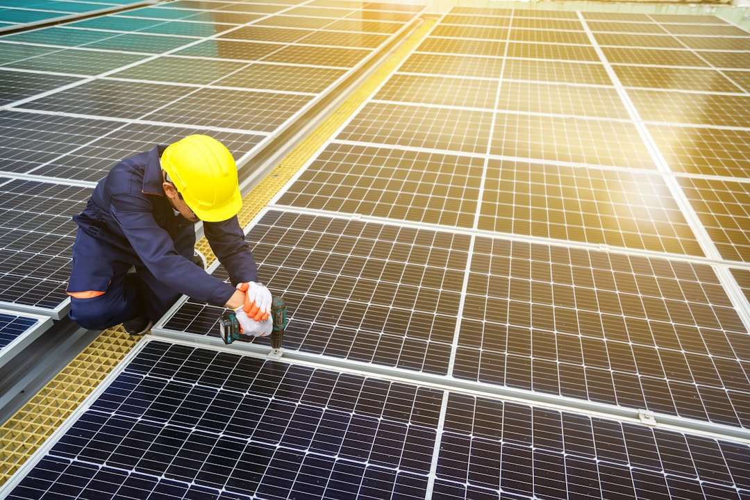 A man in a hardhat working on a solar panel