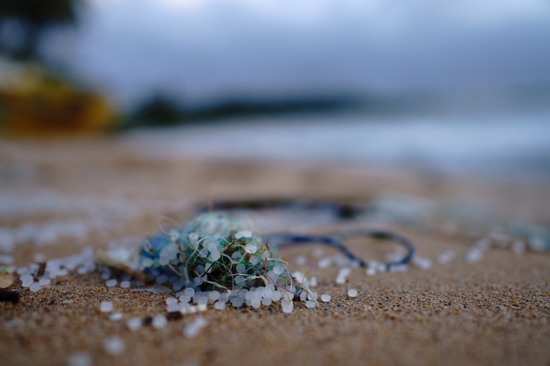 green and brown microplastics on brown sand