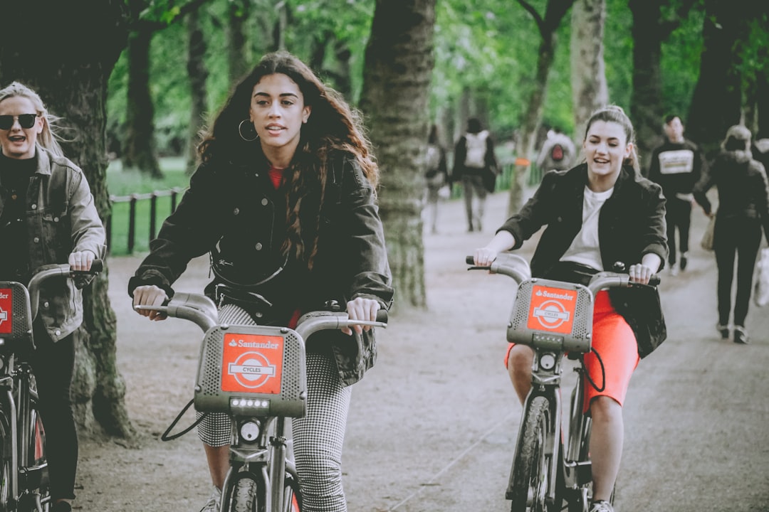 three women riding bicycles in a park