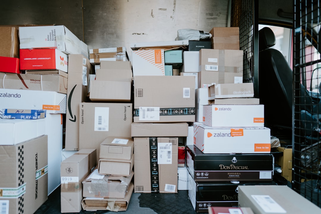 A stack of cardboard shipping boxes inside the back of a delivery van
